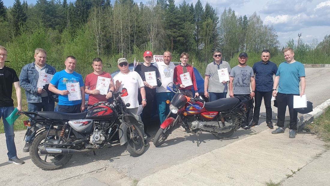 Группа выпускников автошколы с грамотами и учебными мотоциклами