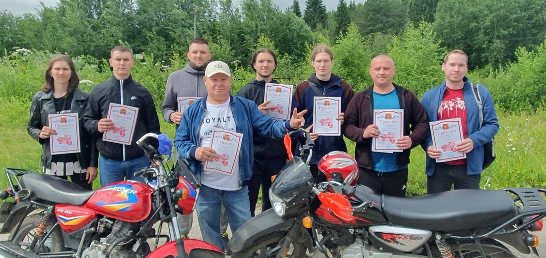 Выпускники автошколы с грамотами у мотоциклов