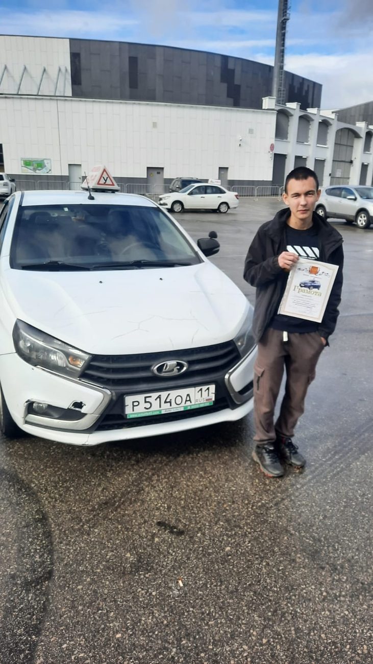 Выпускник со свидетельством у белой учебной Лады Весты